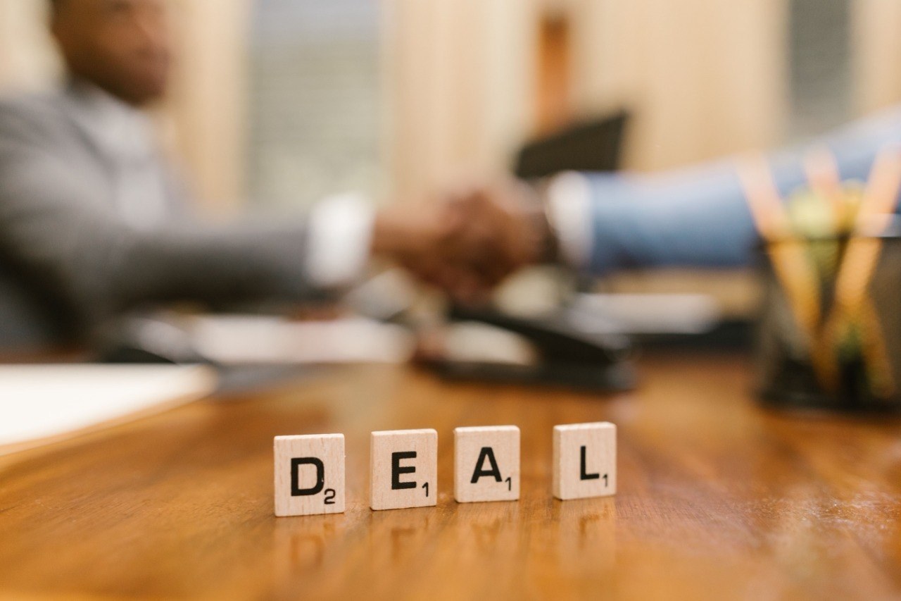 Real businesspeople signing an acquisition agreement